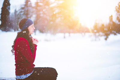Girl in snow praying