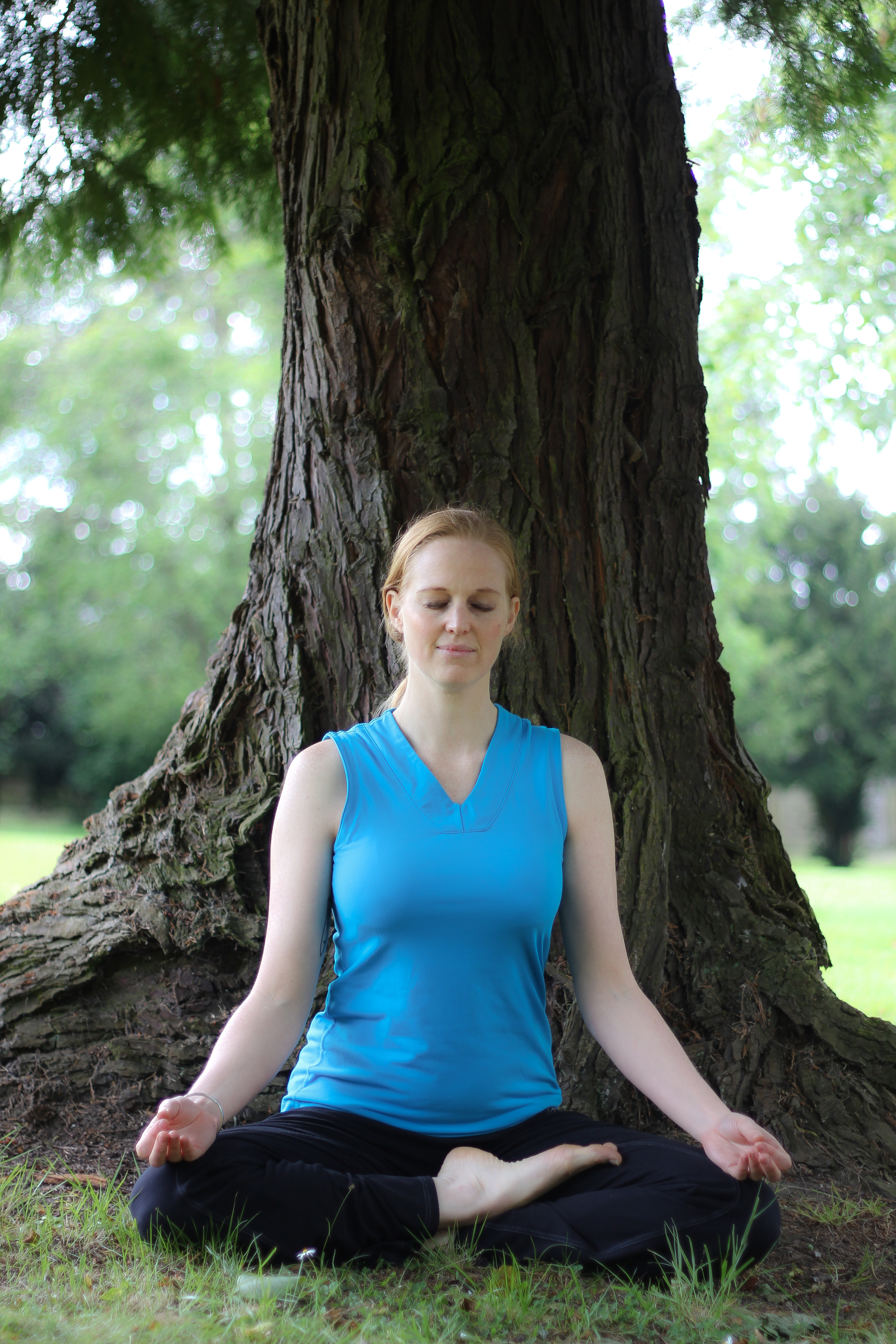 Woman meditating under a tree