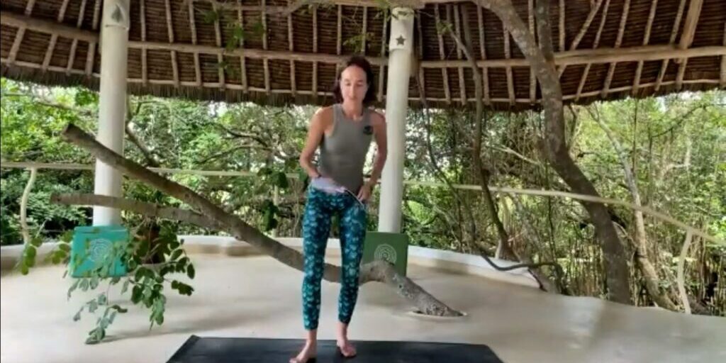 Aja Krystall leading a joyful movement yoga class for Dru Yoga, celebrating the body with kindness and ease.