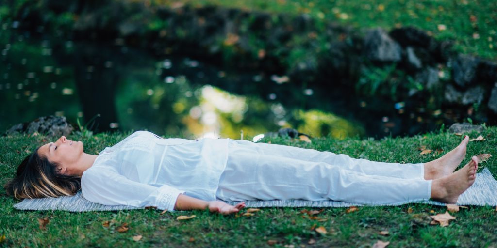 Corpse Position, Savasana, Meditation Corpse Position, Savasana, Meditation. Young woman practicing yoga and meditating by the water.